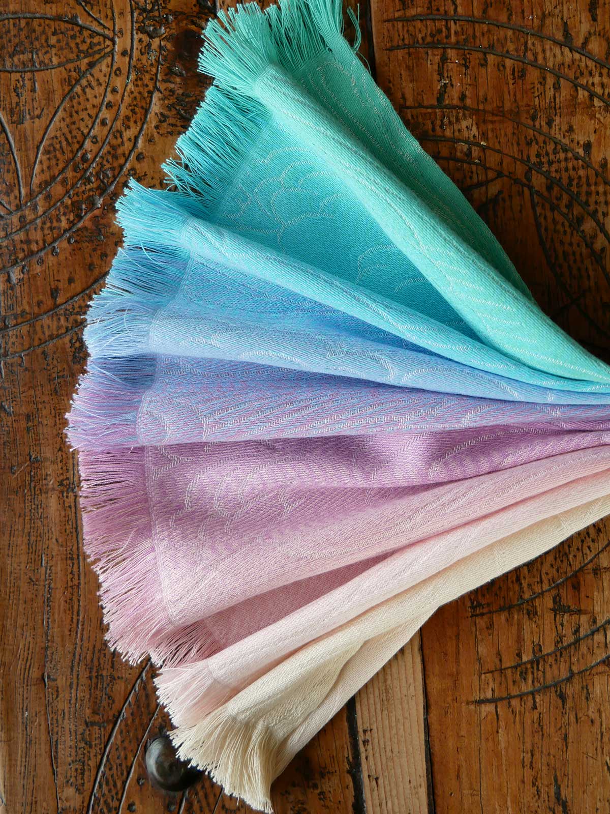 Color swatch with gradient shades of blue, purple, and pink on a wooden surface