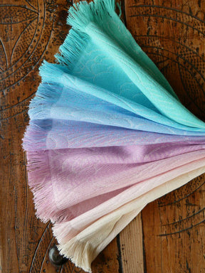 Color swatch with gradient shades of blue, purple, and pink on a wooden surface