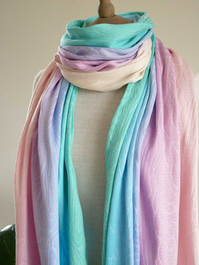 Pastel colored scarf draped over a mannequin against a neutral background