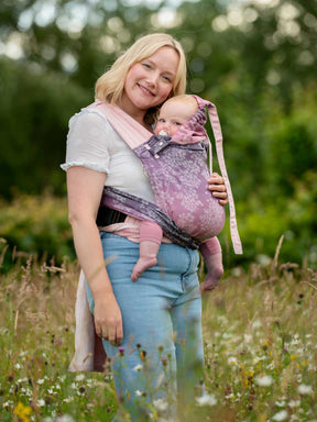 Cairis baby carrier with hood up to keep baby cosy. 