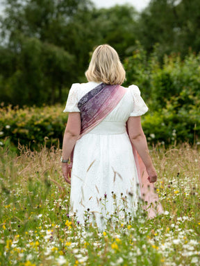 Back view of model in white dress wearing a ring sling. 