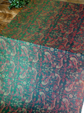 Patterned cloths with red and green designs on a wooden surface.