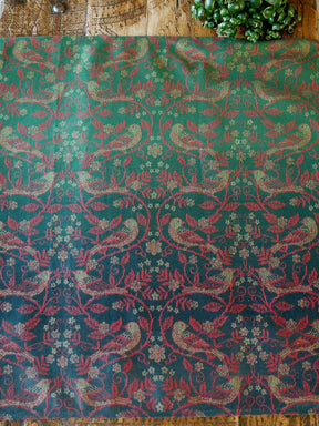 Patterned fabric with birds and floral designs on a wooden surface