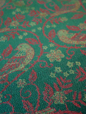 Close-up of a green fabric with red floral and leaf pattern