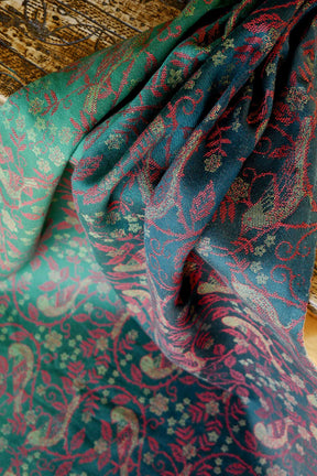 Close-up of a patterned fabric with green, red, and black colors.