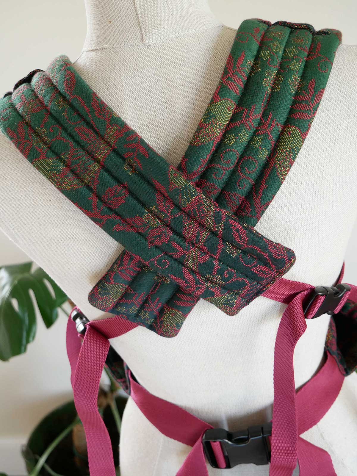 Green and red patterned straps on a mannequin with a red strap.