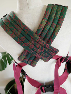 Green and red patterned straps on a mannequin with a red strap.