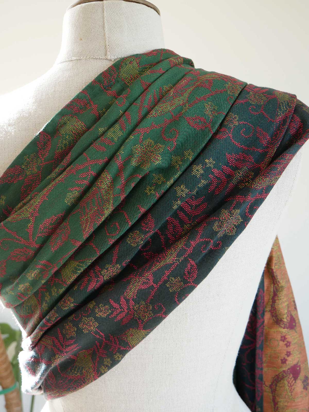 Green and red patterned sling draped over a mannequin