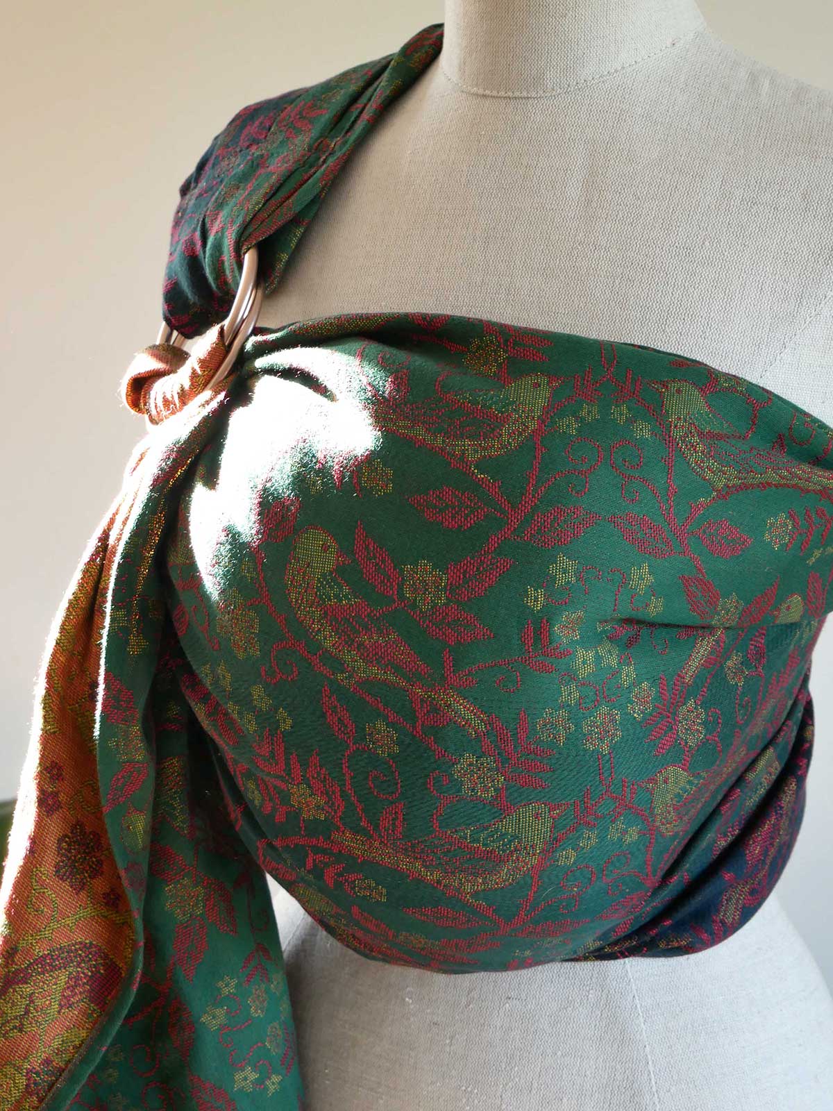 Green patterned sling draped over a mannequin on a white background