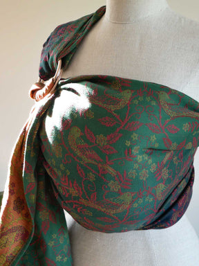 Green patterned sling draped over a mannequin on a white background