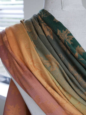 Green, orange, and brown reverse view of a ring sling on a mannequin.