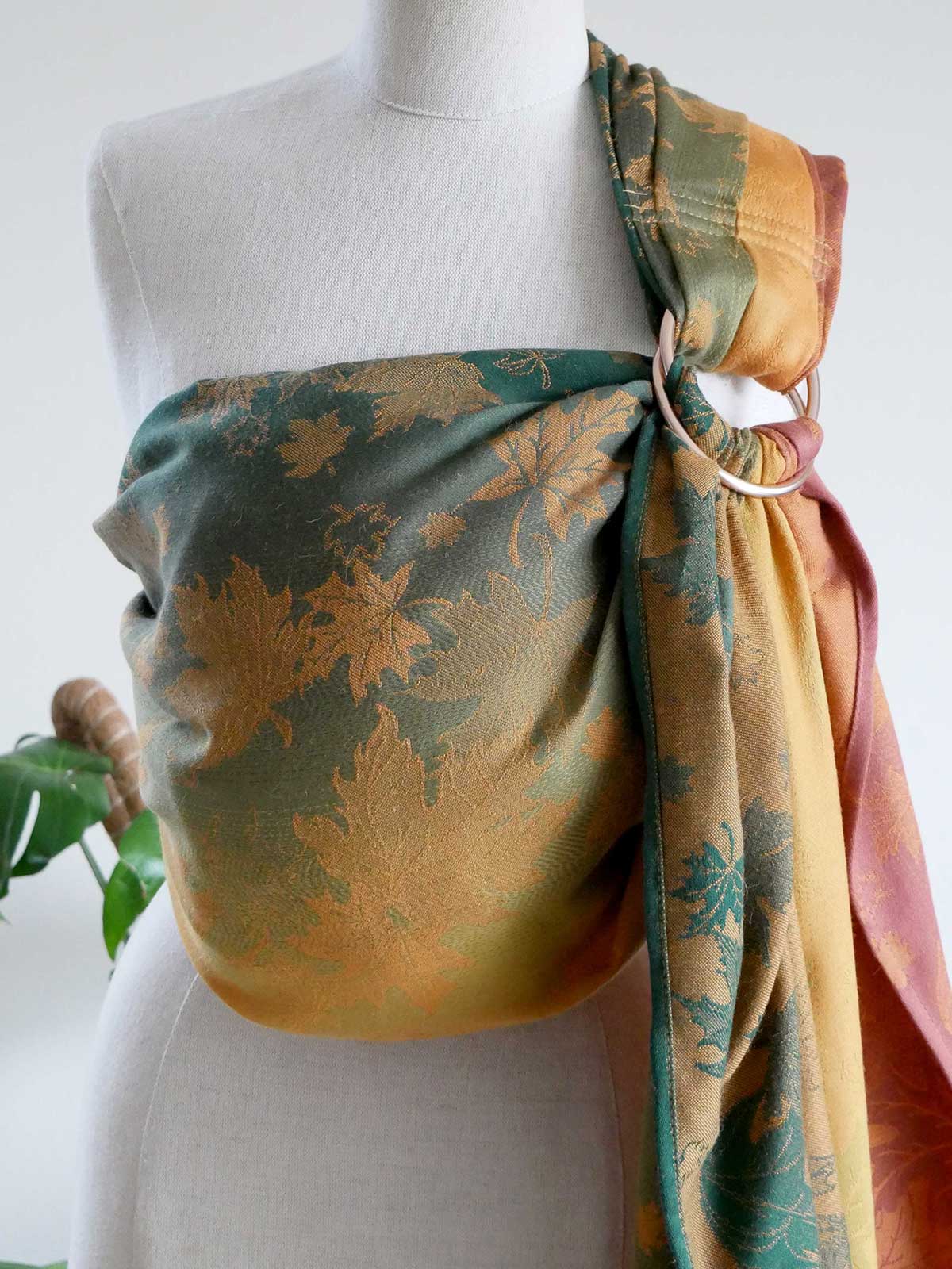 Mannequin wearing an autumnal leaf patterned ring sling.