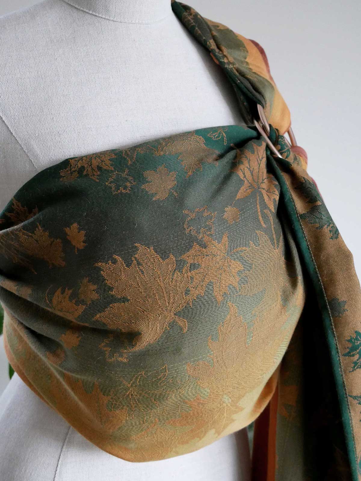 Leaf patterned ring sling on a mannequin with a white background.