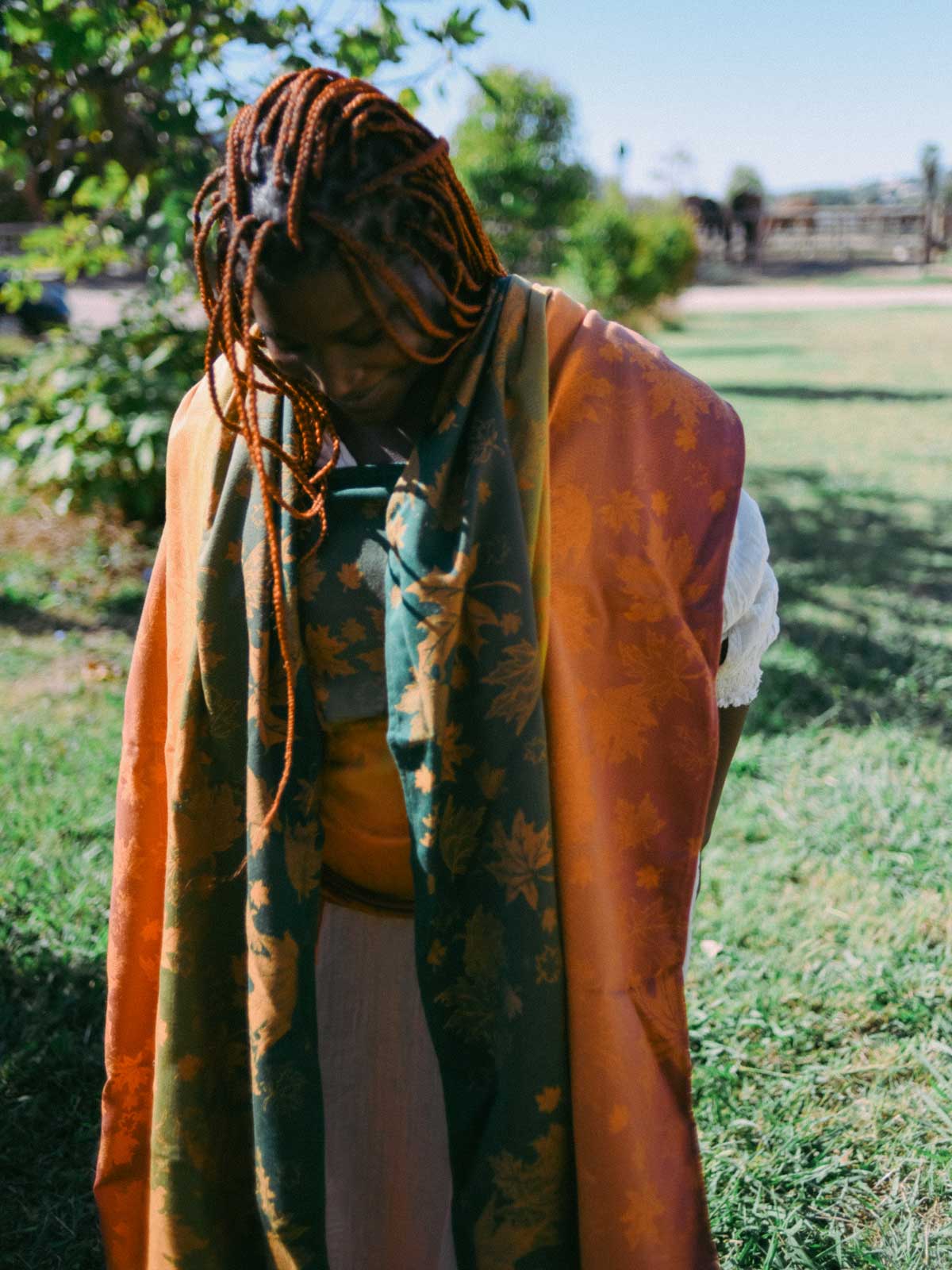Person wearing a colorful baby wrap in an outdoor setting