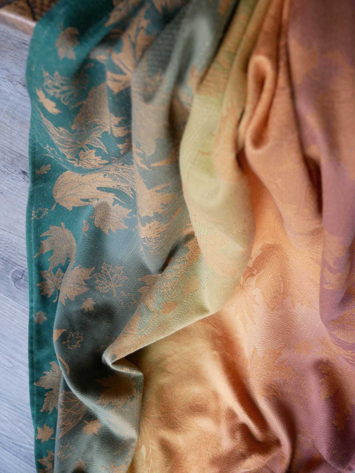 Close-up of a fabric with leaf pattern in green and orange colours.