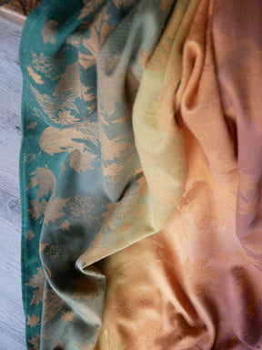 Close-up of a fabric with leaf pattern in green and orange colours.
