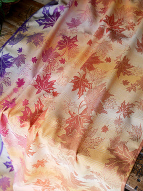 Reverse of a fabric with leaf patterns laid over a wooden table