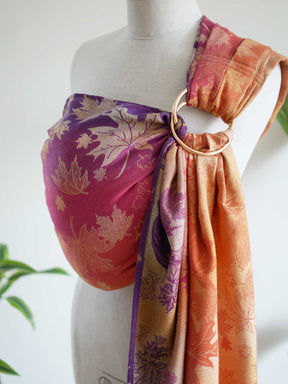 Side view of autumnal coloured ring sling with leaf patterns on a manneuin