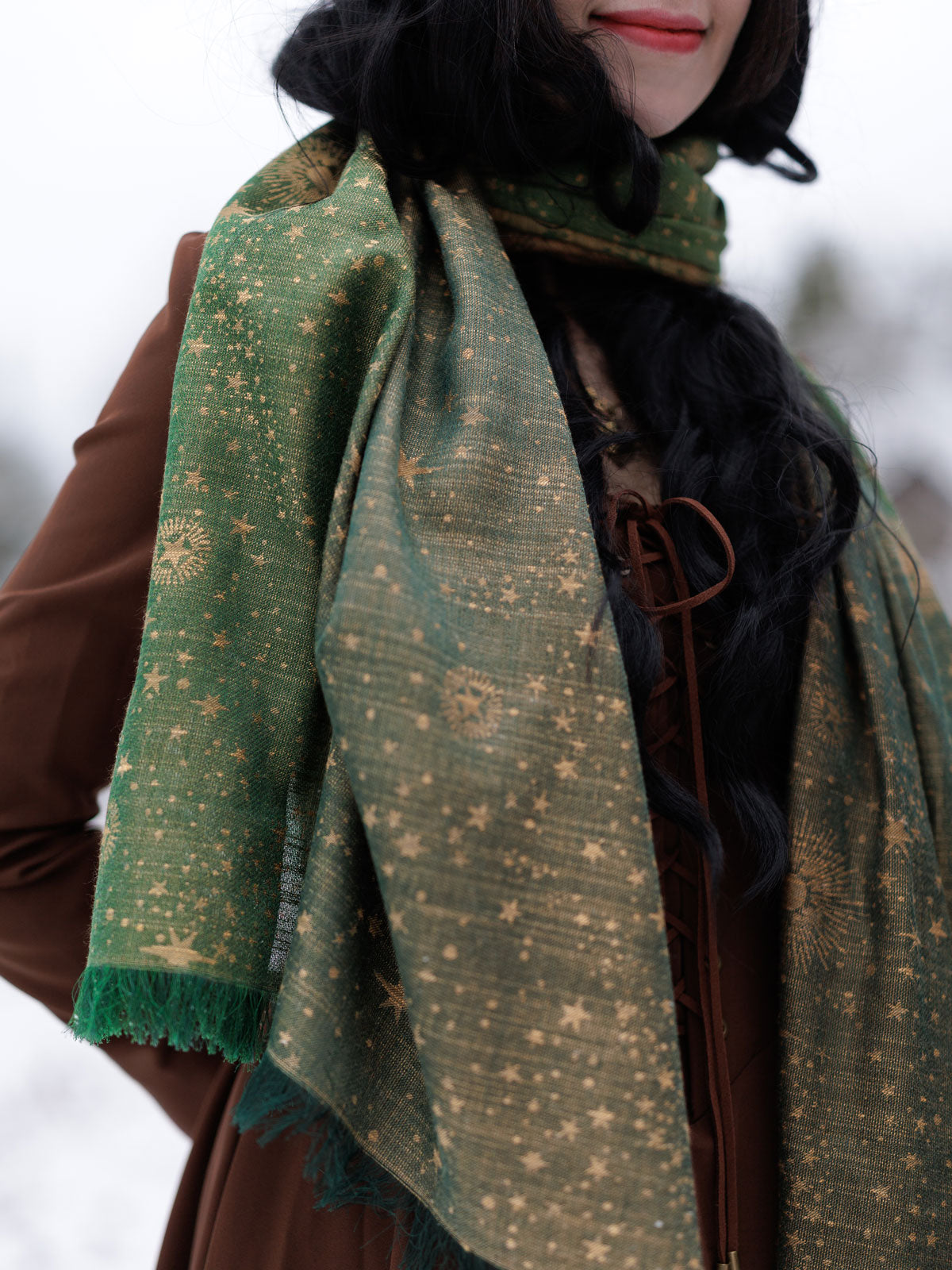 Person wearing a green patterned scarf with a blurred background