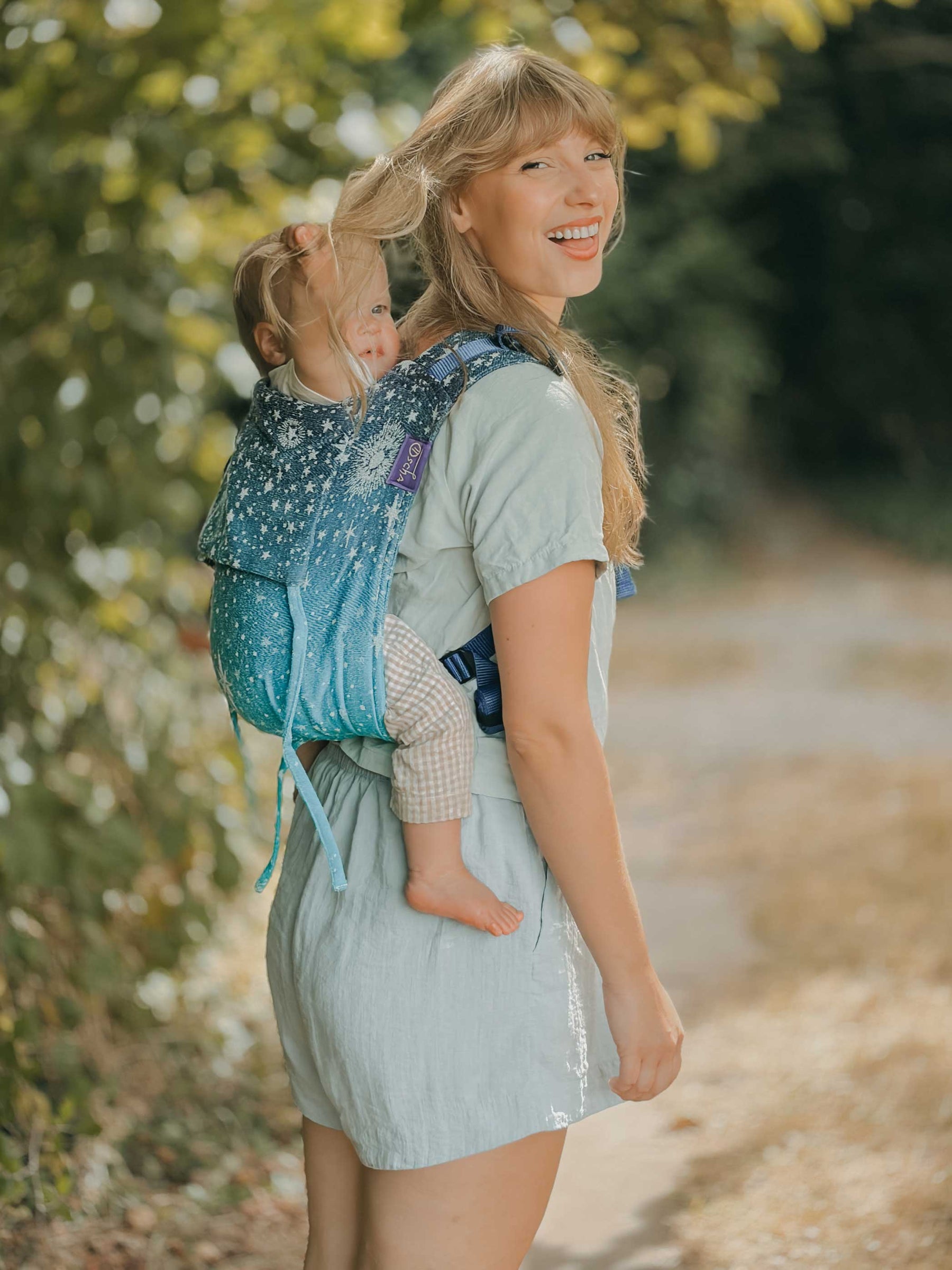 Baby is playing with model's hair in a playful happy shot. 