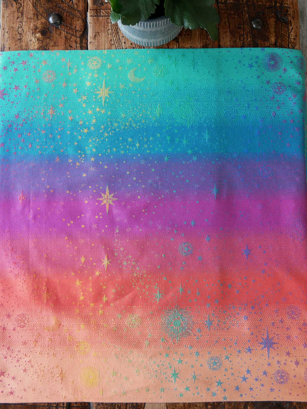 Colorful fabric with star and moon patterns on a wooden surface