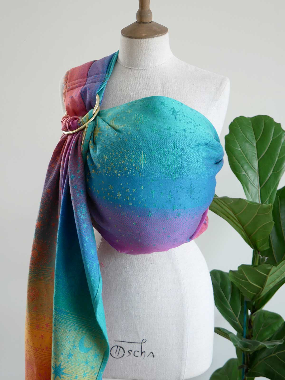 Mannequin wearing a colorful ring sling with a gradient of blue, purple, and pink, against a white background.