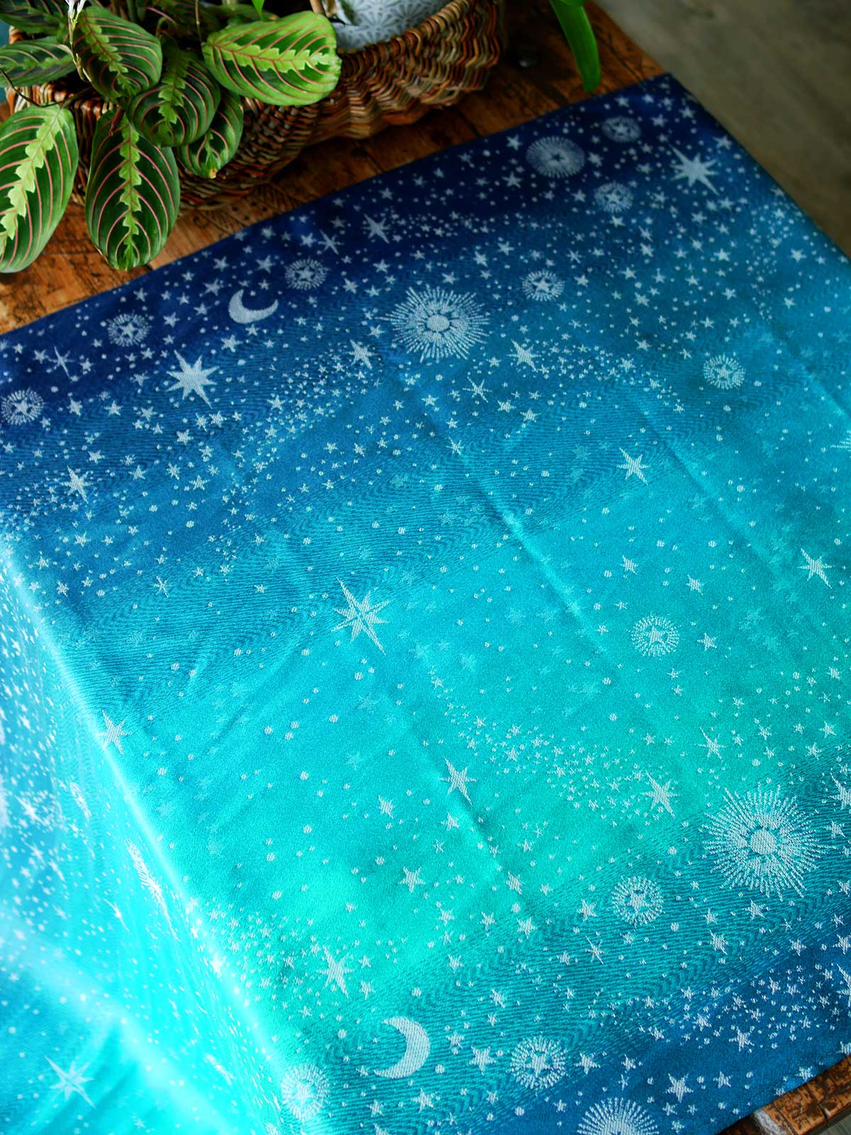 Blue and teal fabric with starry pattern laid flat on a wooden table