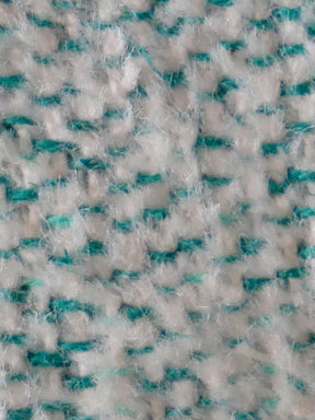Close-up of a textured fabric with white and teal pattern