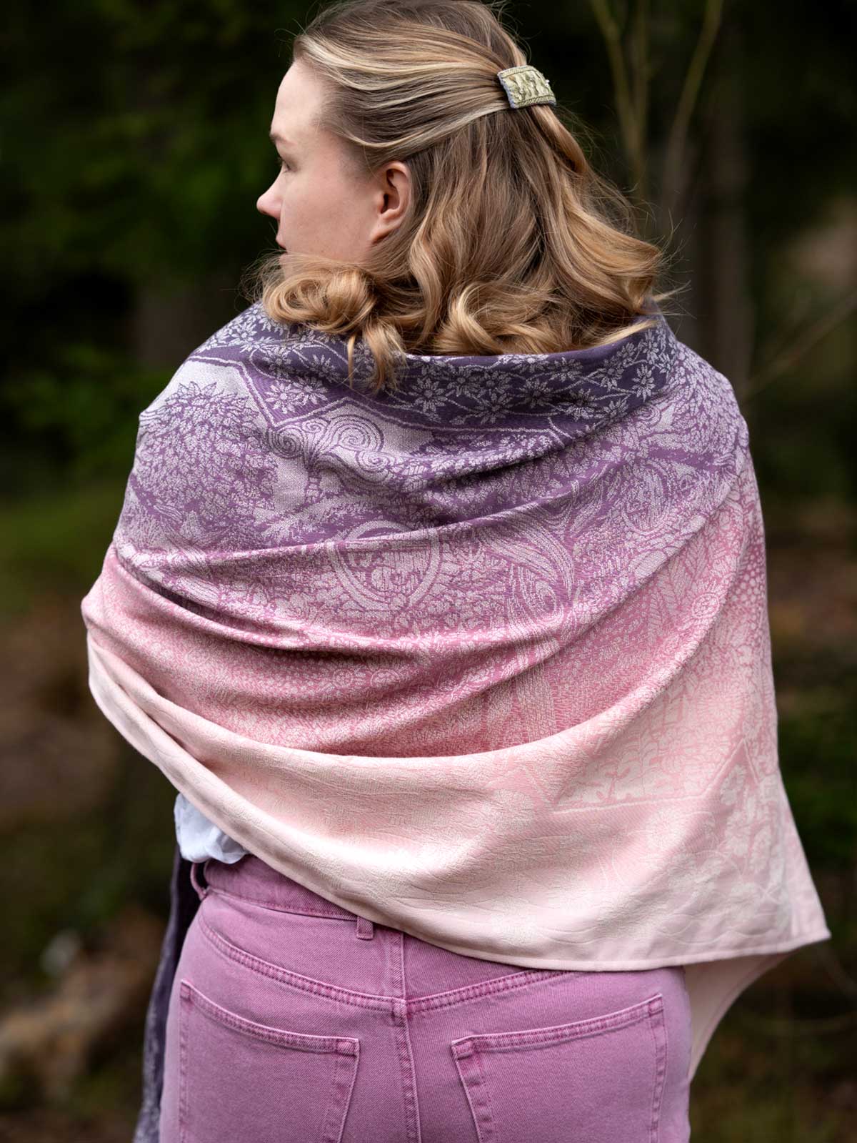 The back of a woman wearing a pinky purple shawl