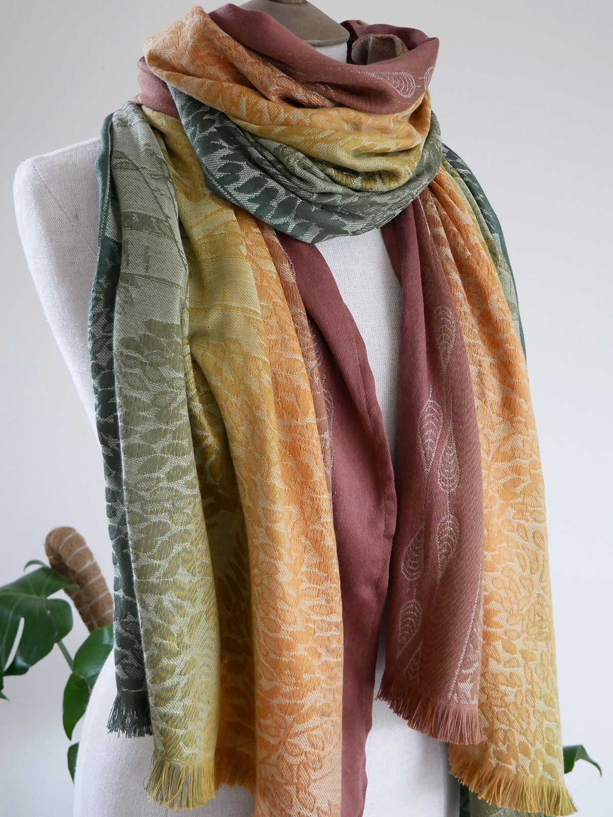 Multicolored scarf draped over a mannequin against a white background