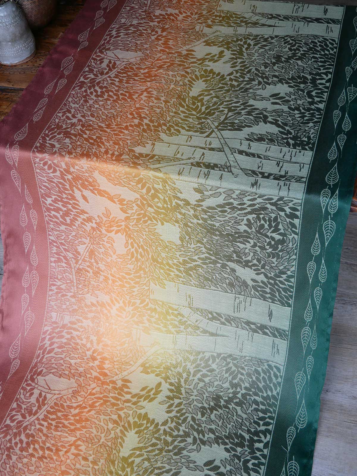 Textile with leaf pattern on a wooden surface