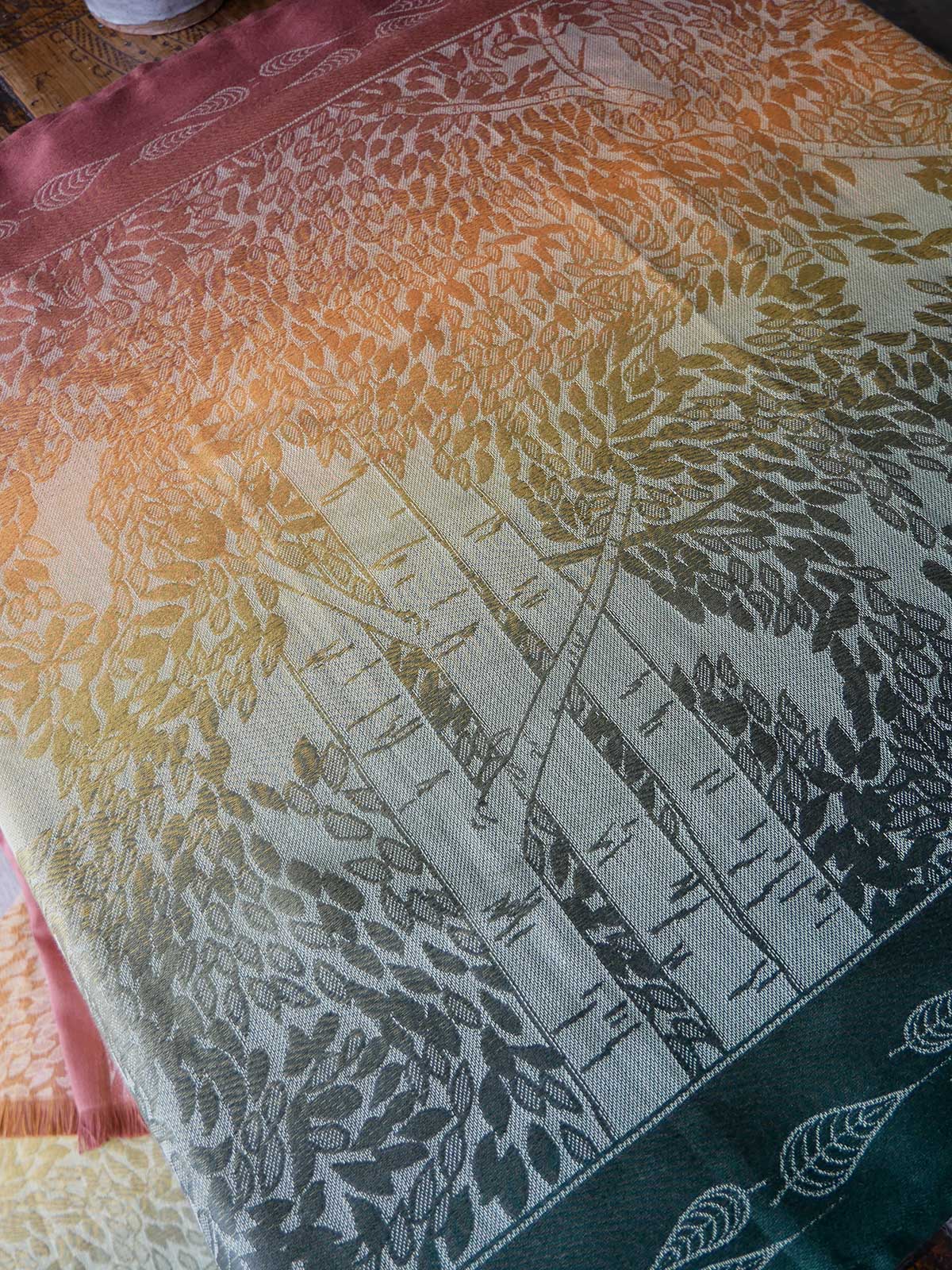 Fabric with a gradient pattern of trees and leaves on a wooden surface