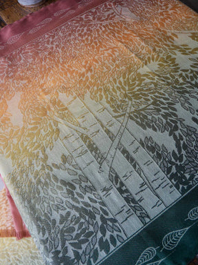 Fabric with a gradient pattern of trees and leaves on a wooden surface
