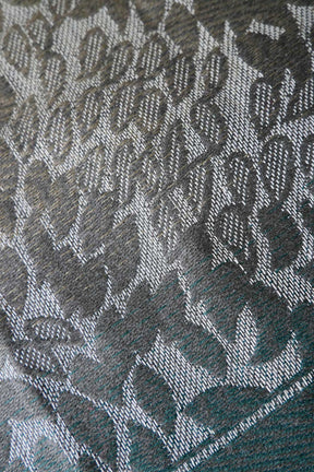 Close-up of a textured fabric with a leaf pattern in green. 