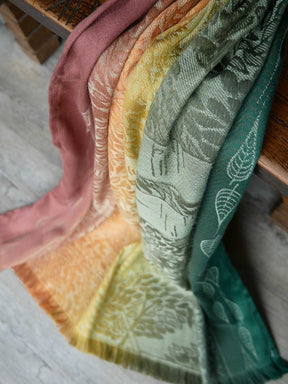 Close-up of fabric in orange and green on a wooden surface.