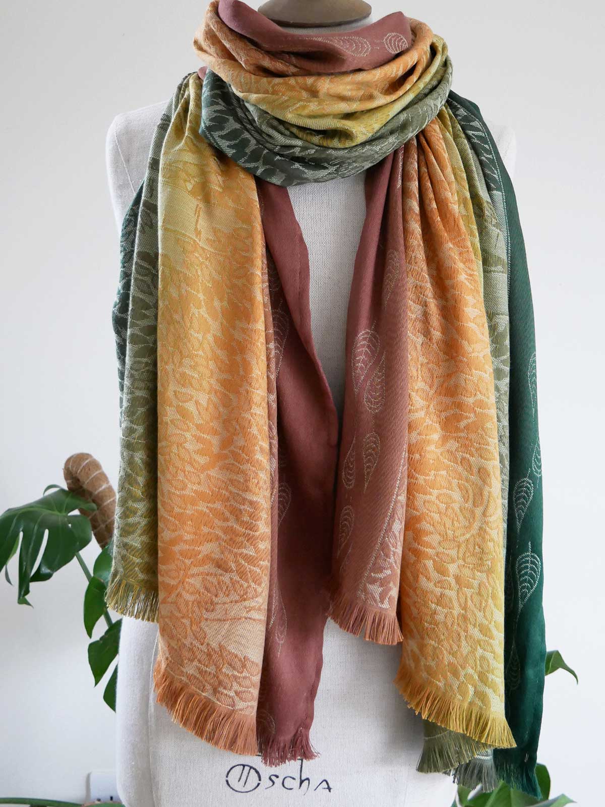 Multicolored scarf draped over a mannequin with a white background