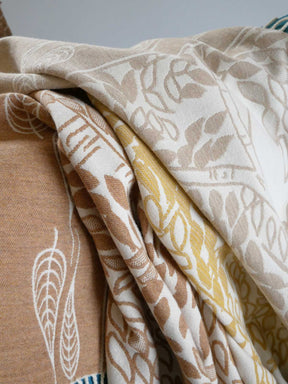Collection of patterned fabrics in beige, brown, and yellow.