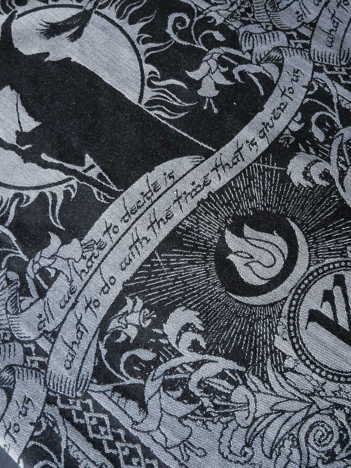 Decorative fabric with intricate patterns and text, featuring animals and symbols.