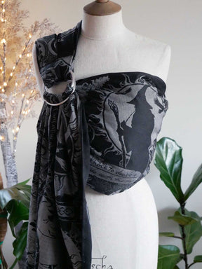 Mannequin wearing a black and silver patterned ring sling with decorative elements.