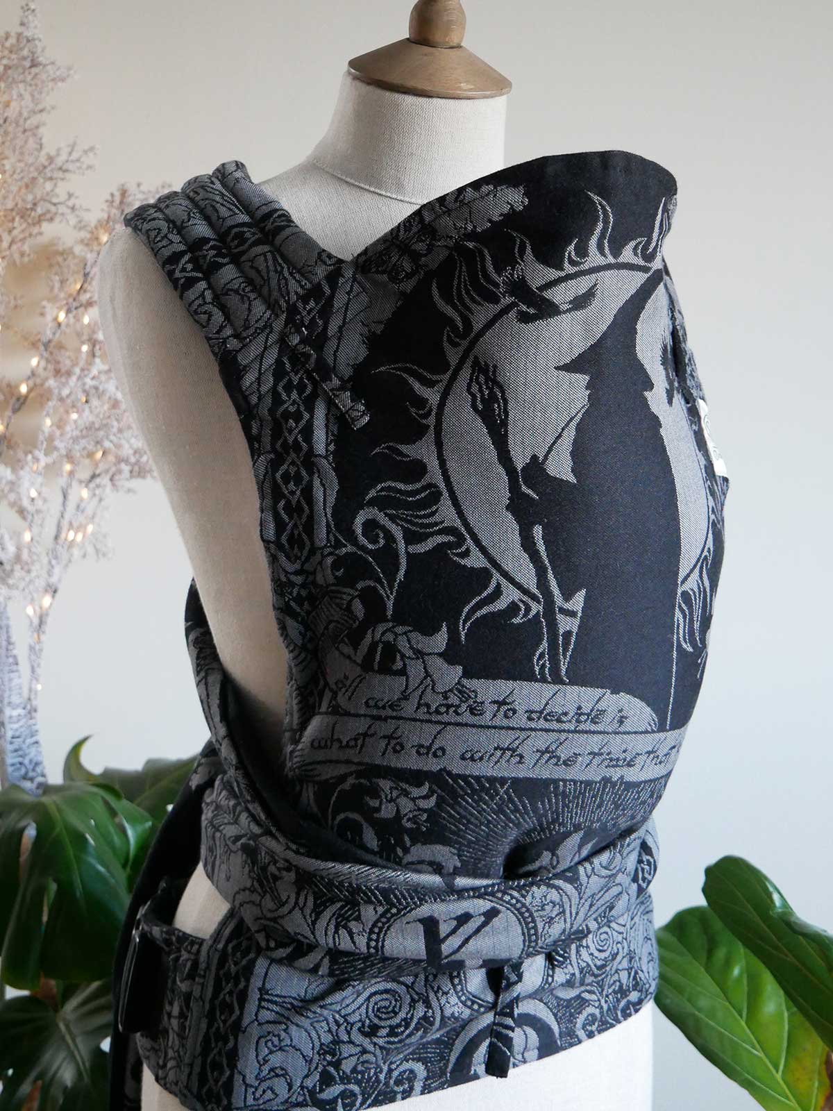 Black and silver patterned carrier on a mannequin with a decorative background