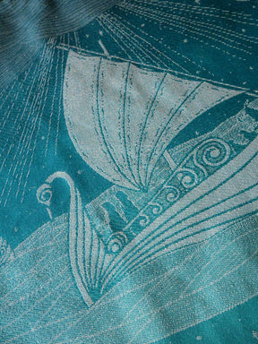 Close-up of a textured fabric with a stylized sailboat design on a teal background