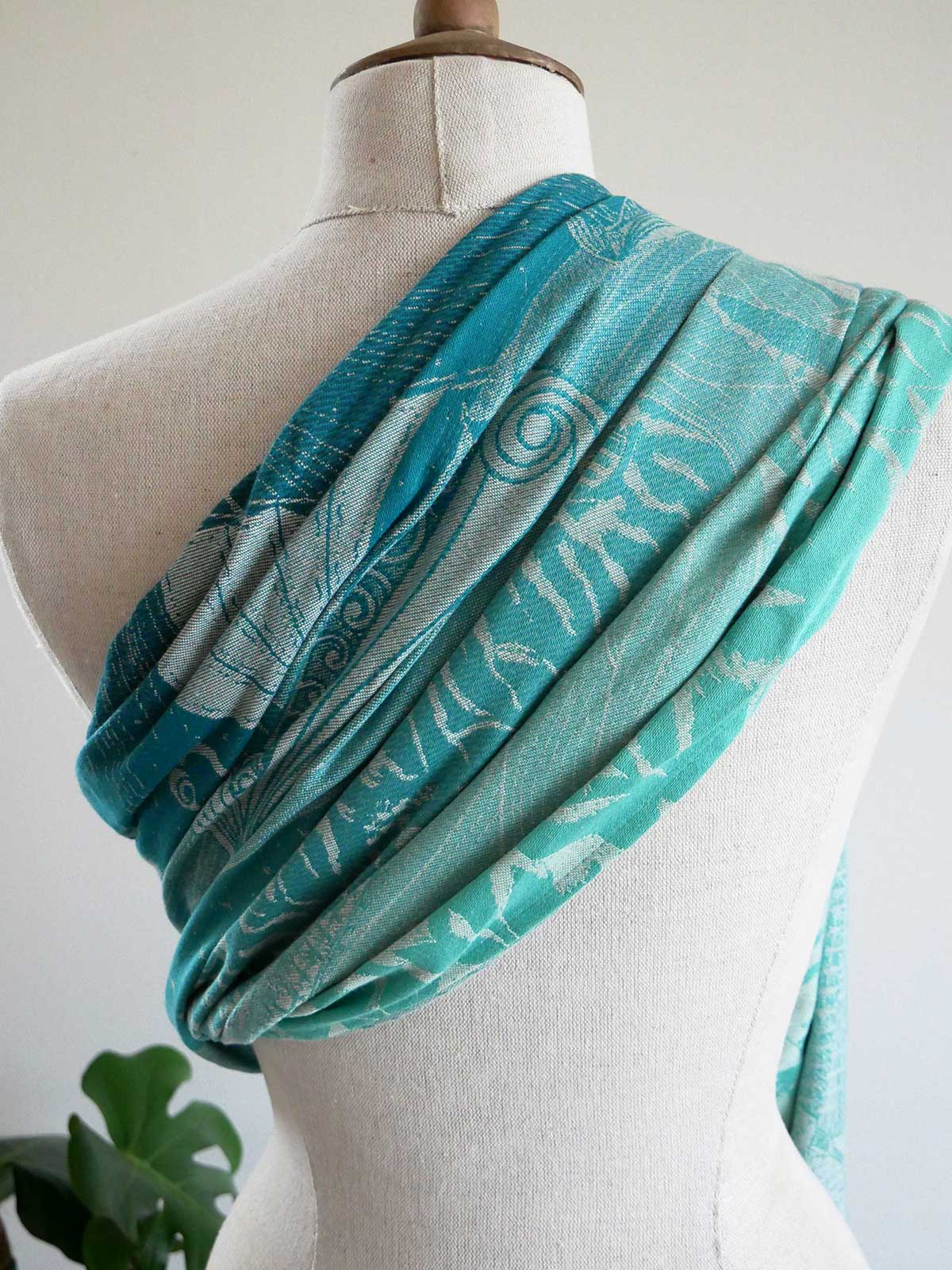 Teal patterned sling on a mannequin with a white background