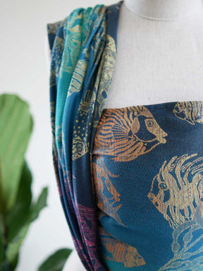 Close up of a blue teal woven wrap with tropical fish patten on a mannequin