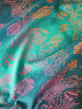 Close up of a blue teal fabric with tropical fish patten