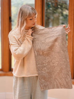 Woman holding a scarf with highland cow desing