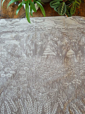Woodcut-style illustration of highland cows in a field with flowers and plants.