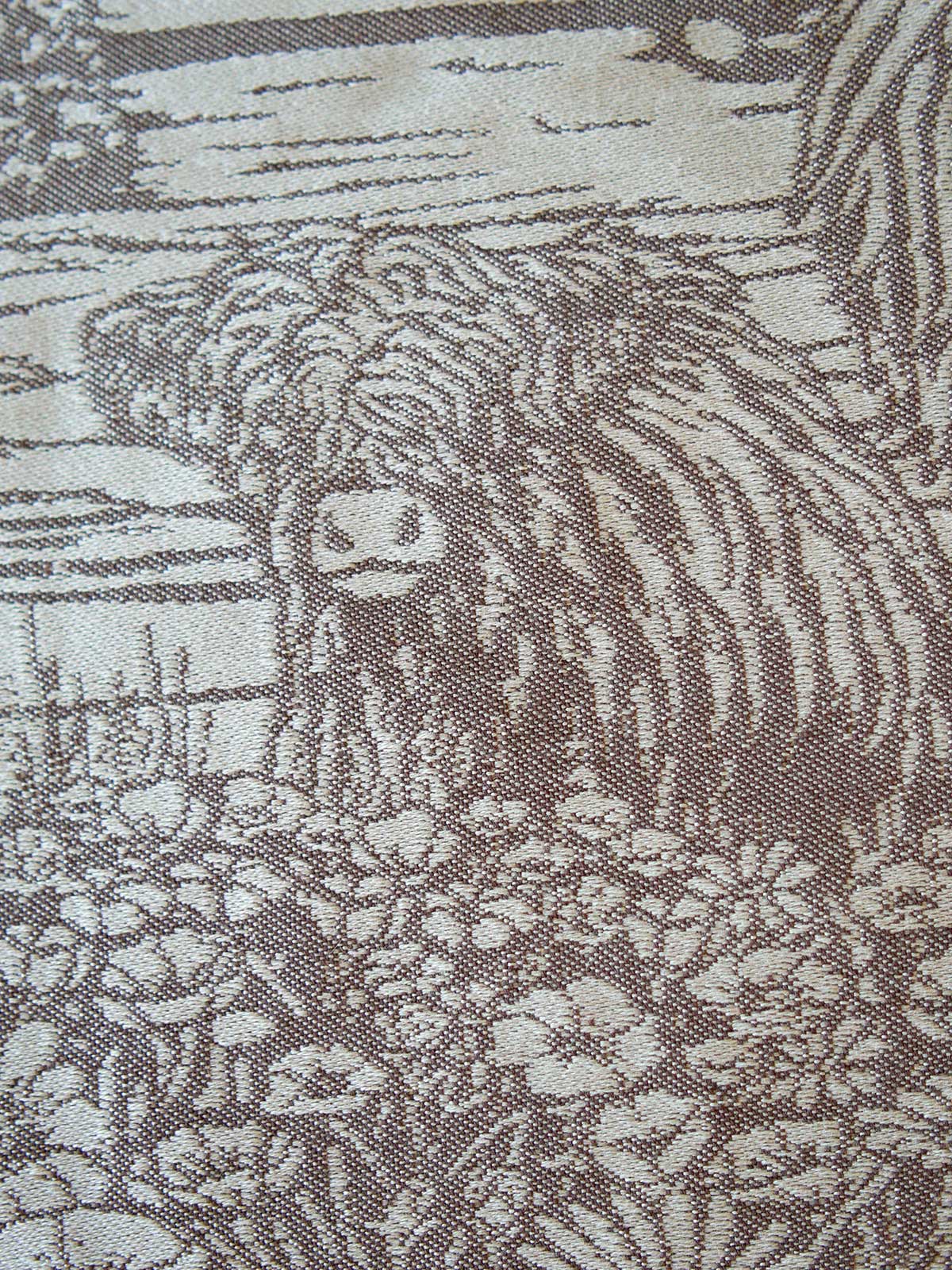 Close-up of a fabric with a pattern of a cow and landscape