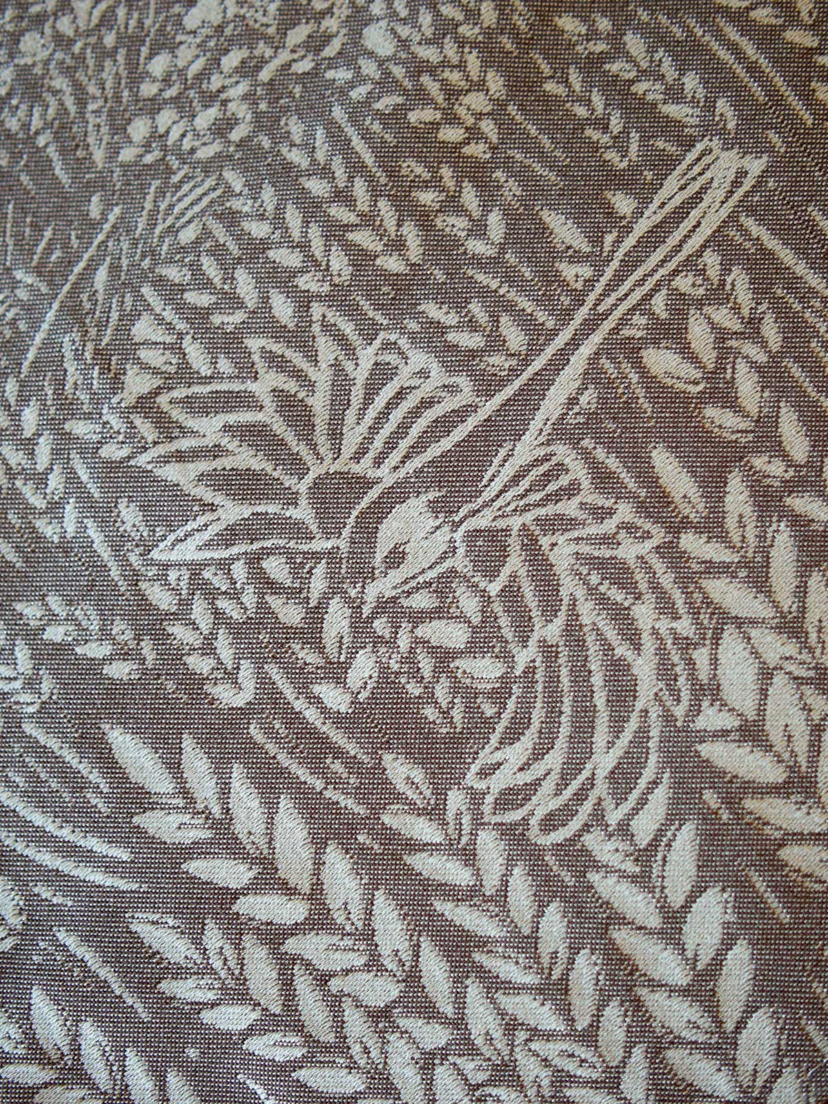 Textile with leaf pattern and bird design on a brown background