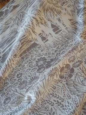 Textile with floral and abstract patterns in brown on a beige background
