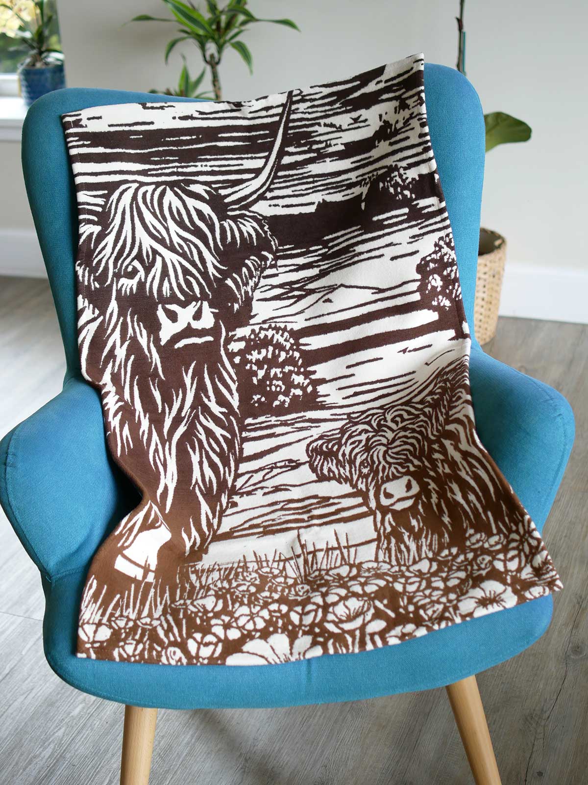 Baby blanket with highland cow design on a chair